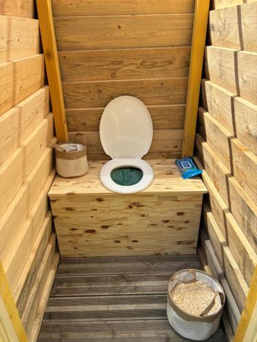 des toilettes dans une salle de bain en bois dans un sauna dans l'établissement Tipi du lac, à Lacépède