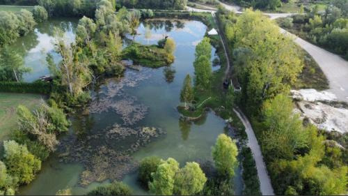 an aerial view of a river with trees and a bridge at Tipi du lac in Saint-Thibault