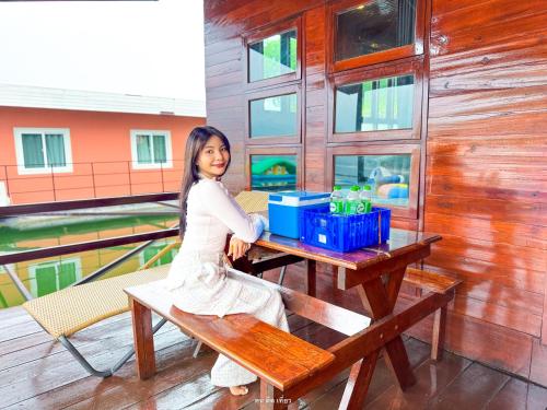 a young girl sitting at a picnic table at เดอะวอเตอร์ปาร์ครีสอร์ท- The Water Park Resort in Ban Laem Mong Khoi