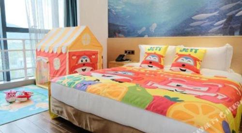 a bedroom with a large bed with a toy house at Beluga Sanya Discovery Ocean World in Shangsimacun