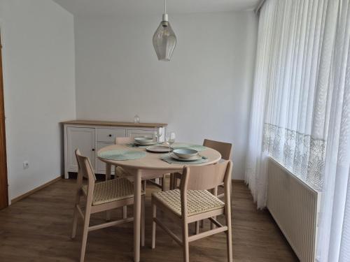 a dining room table with chairs and a table and a kitchen at Ferienhaus am Schloßpark in Aspang Markt