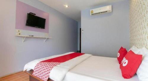 a bedroom with a bed with a tv on the wall at OYO 931 Sor Chareanpanit in Pattaya Central