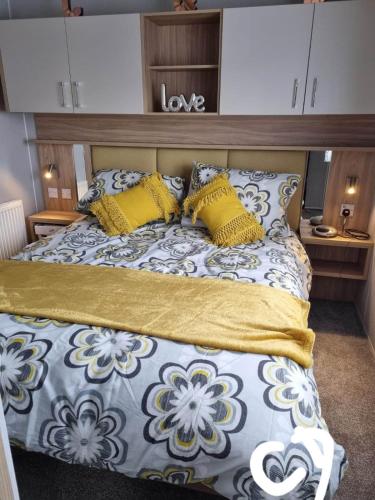 a bedroom with a bed with yellow pillows at Lyons robin hood HV in Meliden