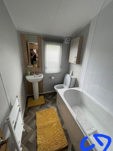 a bathroom with a tub and a toilet and a sink at Lyons robin hood HV in Meliden