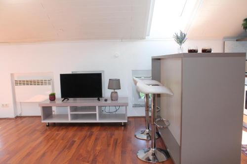 a living room with a television and a table with a stool at Apartments VRAZOVA in Sarajevo