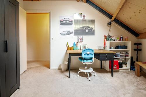 a desk with a blue chair in a room at La Casa Goudacito in Gouda