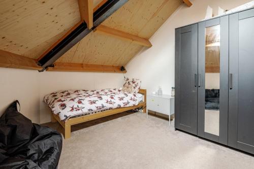 a bedroom with a bed and a cabinet in a attic at La Casa Goudacito in Gouda