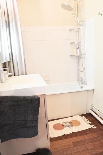 La salle de bains est pourvue d'un lavabo, d'une douche et d'un tapis. dans l'établissement T2 Cozy, Quiet, Parking & near Bordeaux and Airport, à Mérignac