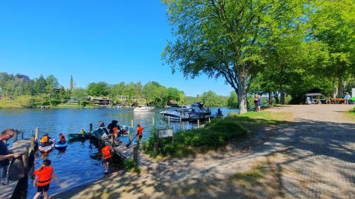 a group of children playing in a river with boats at Skyttehusets Camping in Silkeborg