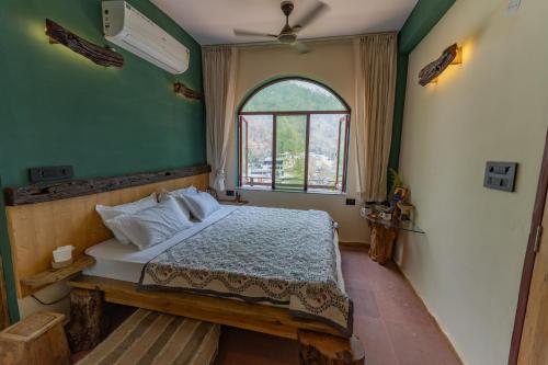 a bedroom with a large bed and a window at Aavya Wellness Retreat Center in Rishīkesh