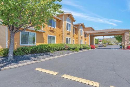 una casa amarilla con un árbol y una calle en Quality Inn near Six Flags Discovery Kingdom-Napa Valley, en Vallejo