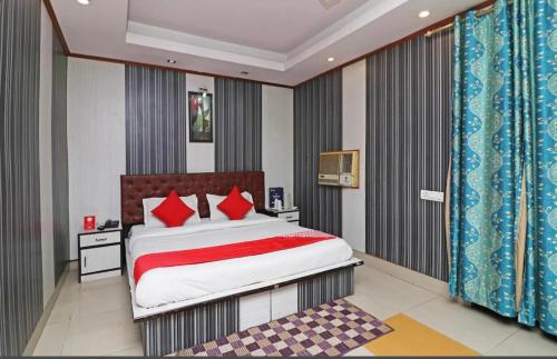 ファリーダーバードにあるHotel akashのベッドルーム1室(大型ベッド1台、赤い枕付)