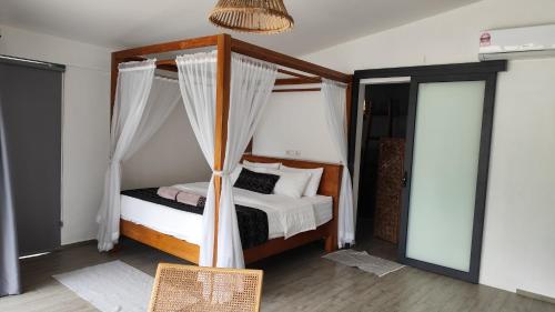 a bedroom with a bed with a canopy at Eagle Bay Retreat Borneo Beach Villas Beach Front in Kumbatang