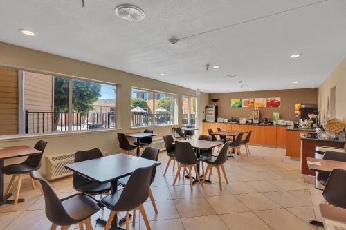 Un restaurante con mesas y sillas y una cocina. en Quality Inn near Six Flags Discovery Kingdom-Napa Valley, en Vallejo
