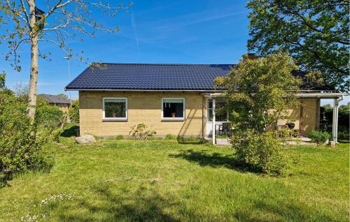 a house with a solar roof on a yard at 3 Bedroom Awesome Home In Tranekær in Tranekær