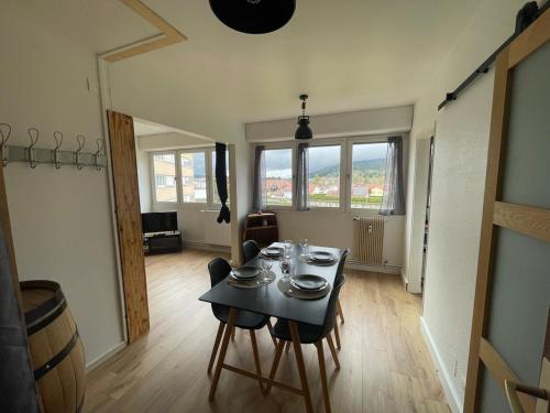 a dining room with a table with dishes on it at Le Doubs Studio in Pontarlier
