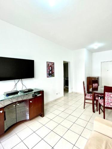 a living room with a flat screen tv on a wall at Apartamento aconchegante no Boqueirão in Santos