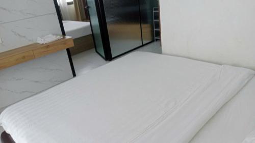 a white bed in a room with a shower at Kellky Homestay Phú Quốc in Phu Quoc