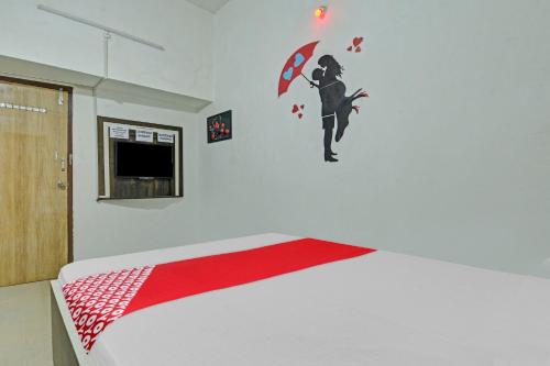 a bedroom with a bed with a red and white bedspread at Hotel O The Goldy Inn in Rātu