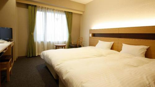 a hotel room with a large bed and a window at Ako Park Hotel in Ako