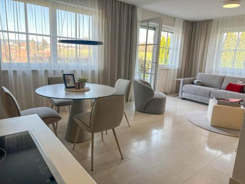 a living room with a table and chairs and a couch at "SONNTAGSKIND" - 2-Zimmer-Apartment mit Terrasse und Privatgarten in Kraiham
