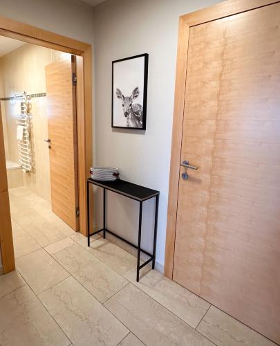 a hallway with a door and a table with a picture at "SONNTAGSKIND" - 2-Zimmer-Apartment mit Terrasse und Privatgarten in Kraiham