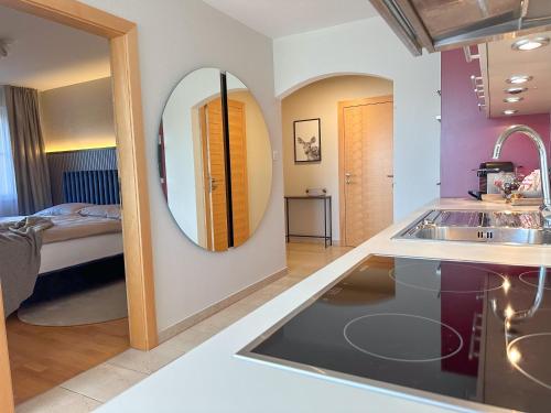 a kitchen with a sink and a mirror in a room at "SONNTAGSKIND" - 2-Zimmer-Apartment mit Terrasse und Privatgarten in Kraiham