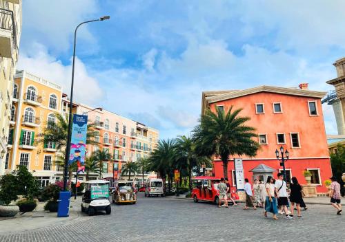 a city street with people walking and cars and buildings at Moonlight Hotel Phu Quoc in Phu Quoc