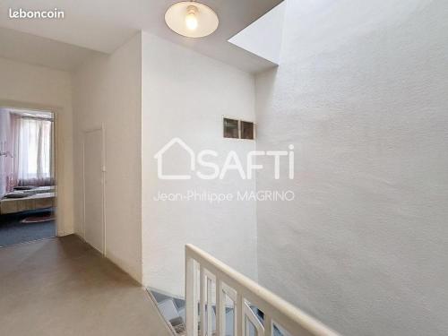 a room with a staircase and a sign on the wall at chez l'habitant in Lavelanet