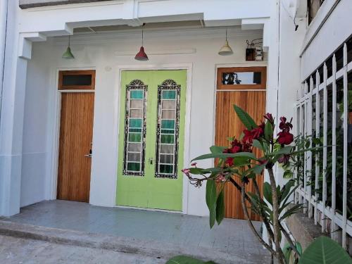 a green door on a house with a plant at Georgetown vintage garden 5pax 2BR Homestay in George Town
