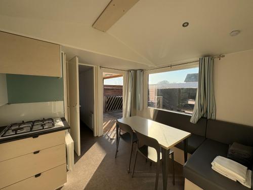 une petite cuisine avec une table et une cuisinière dans l'établissement Le Clos Tranquille, à Gonneville-en-Auge