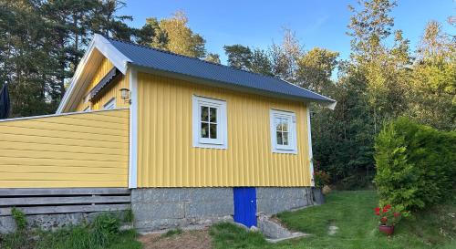 a yellow house with a window on a yard at Söt stuga in Strömstad