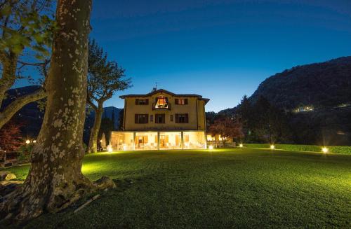 a large house with a tree in the yard at Locanda Sant' Anna in Argegno