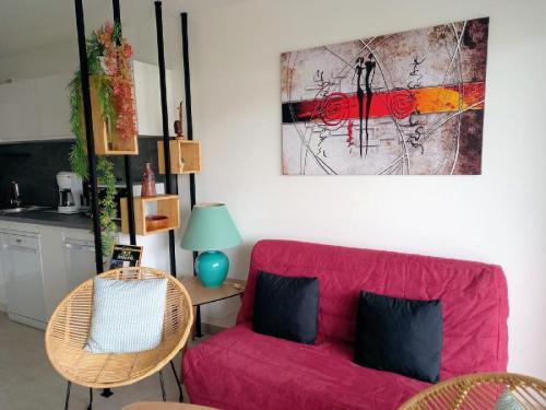 un salon avec un canapé rose et une cuisine dans l'établissement A casa, à Propriano