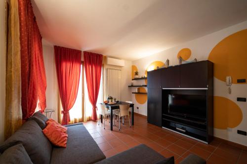 a living room with a couch and a television and a table at In suite lake 3 in Pilzone