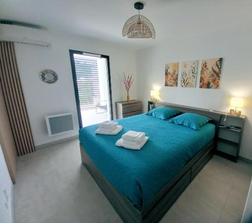 une chambre avec un lit bleu avec des serviettes dessus dans l'établissement A casa, à Propriano