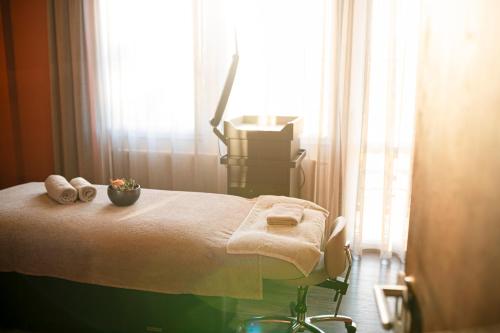 a room with a bed with towels and a window at Das König Ludwig Inspiration SPA in Schwangau