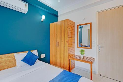 a bedroom with a blue wall and a bed and a table at Madstays Hotel - Medicity Near Medanta Hospital in Gurgaon