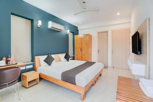 a bedroom with a bed and a desk and a television at Madstays Hotel - Medicity Near Medanta Hospital in Gurgaon