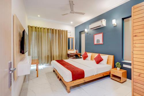 a hotel room with a bed and a television at Madstays Hotel - Medicity Near Medanta Hospital in Gurgaon