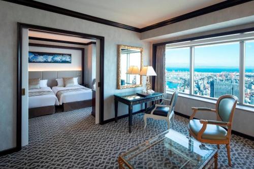 a hotel room with a bed and a desk and window at Yokohama Royal Park Hotel in Yokohama