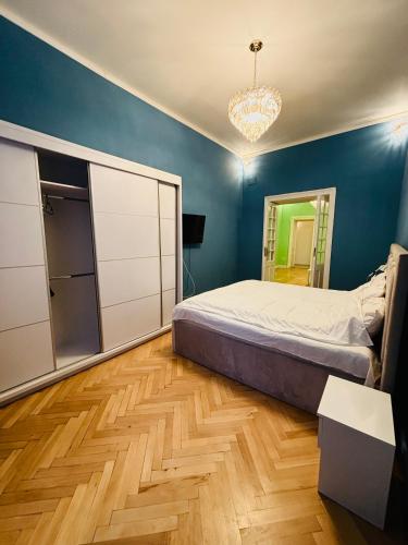 a bedroom with a bed and a blue wall at LAYA Old City in Bucharest