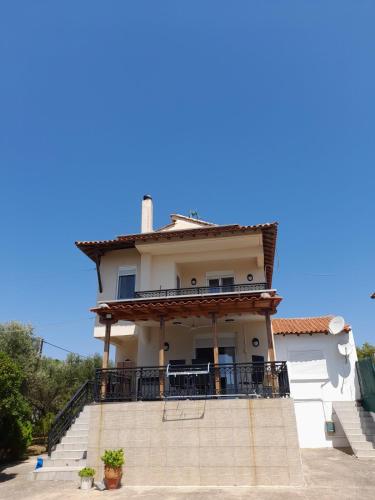 ein weißes Haus mit einem Balkon und einer Treppe in der Unterkunft Angelinas view in Mesimvría