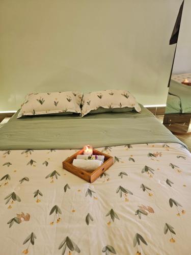 a bed with a wooden tray with a box on it at Bảo Bối House in Cao Lãnh