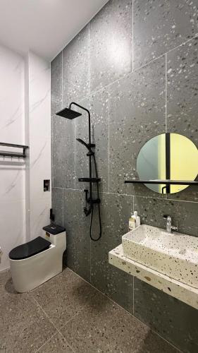 a bathroom with a toilet and a sink and a mirror at Bảo Bối House in Cao Lãnh