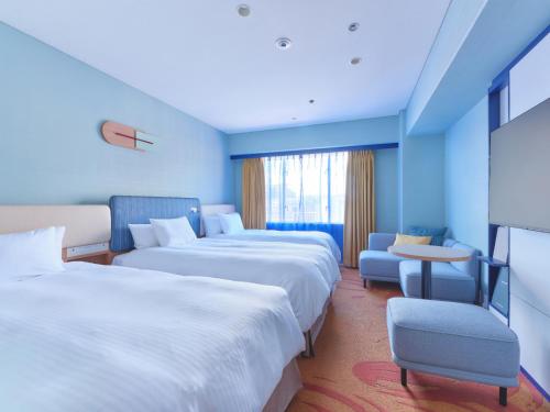 a hotel room with three beds and a chair at Miyako Hotel Kyoto Hachijo in Kyoto