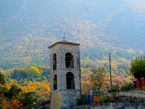 a clock tower sitting on top of a hill at "Apeiros Chora" Hotel, Zagori in Kato Pedina