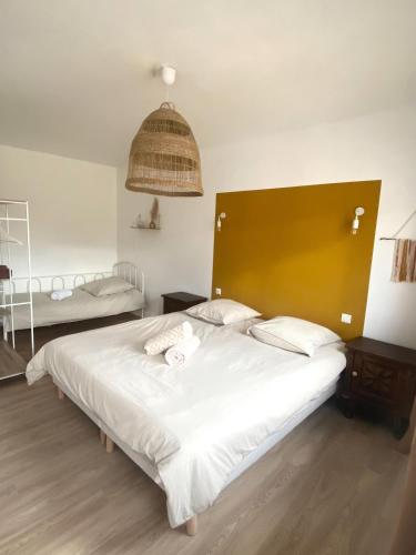 une chambre avec un grand lit blanc avec une grande tête de lit dans l'établissement Mauguio Arty Cosy Wifi Netflix AC, à Mauguio