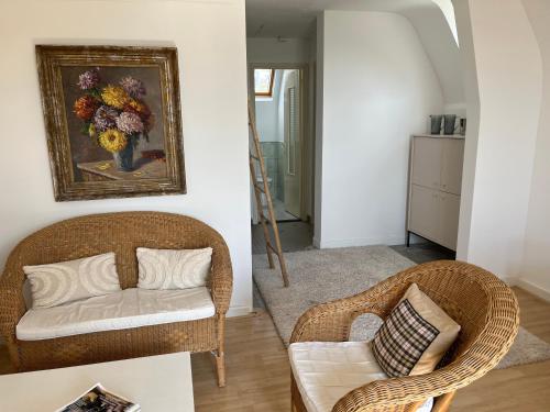 - un salon avec une chaise en osier et un canapé dans l'établissement Villa Médaillon, Appartement privé dans villa, vue mer, à Criel-sur-Mer