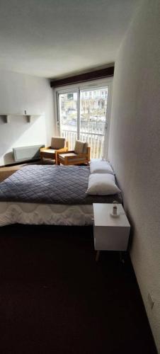 une chambre avec un grand lit et une fenêtre dans l'établissement Résidence Ayre - Spacieux T2 proche du centre de Barèges MAE-1601, à Barèges